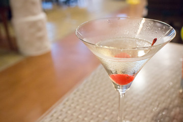 Cocktail martini with red cherry in the glass, close up shot