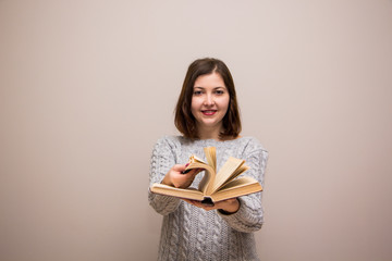 Portrait of young brunette woman with book in her hand