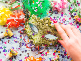 Colorful cranival Mardi gras background with masquerade carnival mask and confetti, streamers, bows. Party items.
