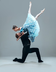 Like a cloud. Beautiful contemporary ballroom dancers isolated on grey studio background. Sensual proffessional artists dancing walz, tango, slowfox and quickstep. Flexible and weightless. - obrazy, fototapety, plakaty