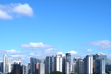 Flat cityscape with blue sky, white clouds and sun. Modern city skyline flat panoramic background....