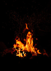 Camp fire in the night, bright flames, black background	