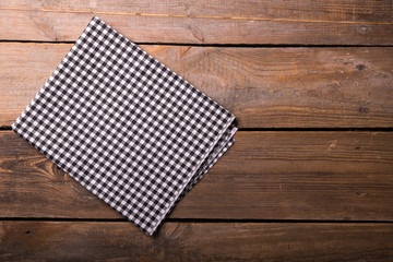 Empty wooden deck table and red checked tablecloth over mint wallpaper background