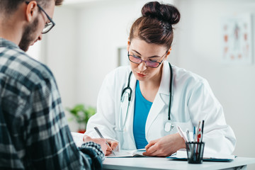 Woman Doctor prescribes medicine to Young Patient