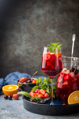 Red wine sangria or punch with fruits and ice in glasses and pincher. Homemade refreshing fruit...