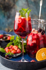 Red wine sangria or punch with fruits and ice in glasses and pincher. Homemade refreshing fruit sangria.