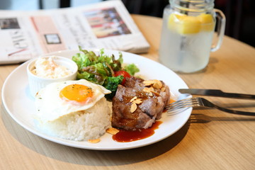 Grilled beaf steak one plate lunch with salad, potato salad and fried egg.
