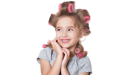 Portrait of emotional little pretty girl with hair curlers posing isolated
