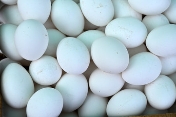 White eggs on a black background. A heap of eggs on a market in Spain.
