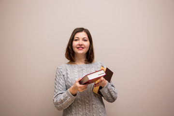 Portrait of young brunette woman with book in her hand