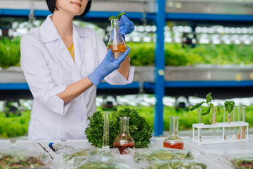 Woman working in greenhouse laboratory feeling busy while working