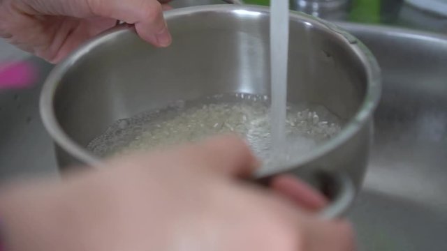 Close-up of washing rice under water before cooking