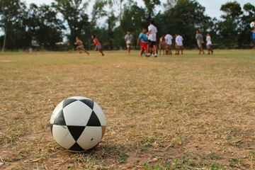 Fototapeta premium Children are playing football on the field in the evening after school, taking blurred pictures