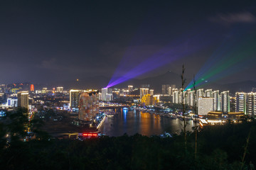 Panorama of night city, sea and buildings of hotels Phoenix Island Resort Sanya