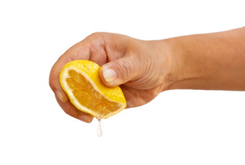 Women's hand squeezing a half of fresh lemon yellow on a white background.