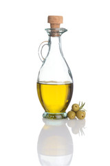 glass bottle of olive oil with fresh green olives
