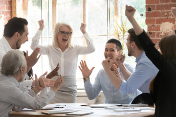 Overjoyed happy corporate business team people scream celebrate triumph