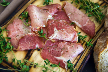 Delicious flavorful ham sliced ​​into strips on a wooden background with spices and fresh thyme. A serving of low-fat succulent farm meat pork. meat product. Food Photography