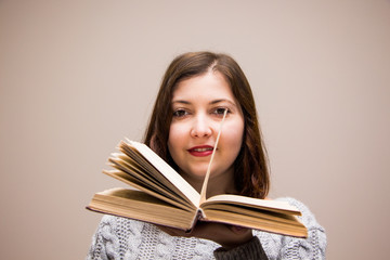 Portrait of young brunette woman with book in her hand