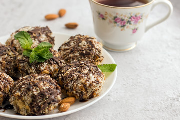 Useful homemade almond cake with coconut flakes on a light background and a cup of tea, copy space