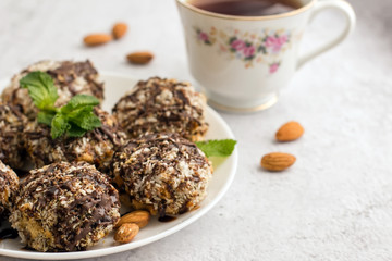 Useful homemade almond cake with coconut flakes on a light background and a cup of tea, copy space