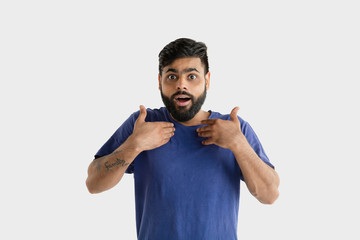 Fototapeta premium Beautiful male half-length portrait isolated on white studio background. Young emotional hindu man in blue shirt. Facial expression, human emotions, ad concept. Astonished, shocked, crazy happy.