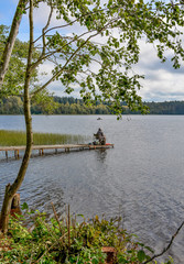 Fototapeta na wymiar Fishermen on the lake with fishing rods fishing on an autumn day.