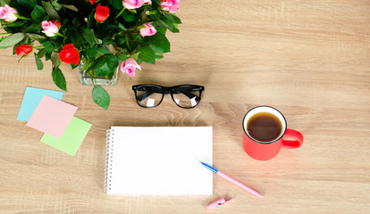 Naklejka na ściany i meble Wooden Desk. White tablet with black-rimmed glasses. Cup of tea. White notebook with space for writing.