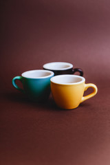Obraz na płótnie Canvas Threee colorfull cups of espresso coffee on dark background