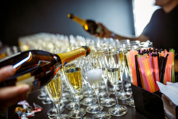 Sparkling wine is poured into a glass at a party