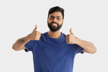 Fototapeta premium Beautiful male half-length portrait isolated on white studio background. Young emotional hindu man. Facial expression, human emotions, advertising concept. Happy, showing the sign of nice or cool.