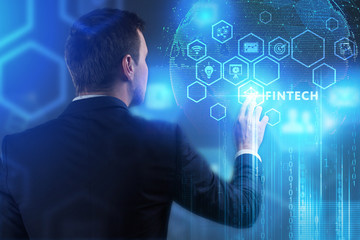 The concept of business, technology, the Internet and the network. A young entrepreneur working on a virtual screen of the future and sees the inscription: Fintech