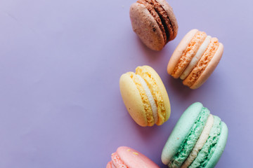 Composition of delicious macaroons on purple background
