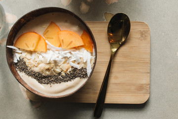 Bowl with sliced persimmon, nuts and chia seeds 
