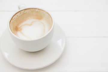 Drinking coffee cup white hart latte art on white wooden.Copy space for you text
