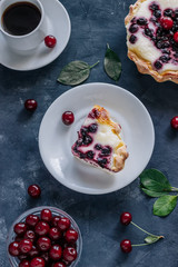 Cherry cheesecake and cup of coffee on the  gray concrete background. Top view.
