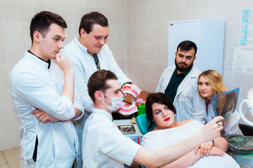 Fototapeta premium Dental clinic. A group of professional doctors discusses dental treatment on x-rays in the office. Modern Medical Education.