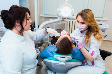 Dental clinic. Professional doctor dentist treats teeth to the patient in the office on modern...