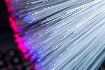 Glowing colorful optical fibres over laptop computer keyboard , image for background.