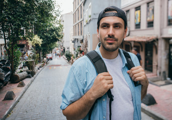 A man tourist walks through the streets with a backpack