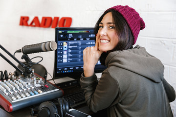 Beautiful happy young female radio host broadcasting