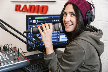 Beautiful happy young female radio host broadcasting