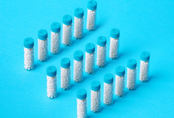 Homeopathic pills on blue background. Alternative medicine