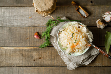 Fermented cabbage, spices on wooden background. Horizontal image with copy space
