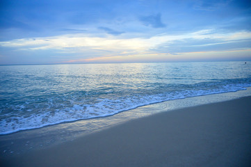 Fototapeta na wymiar Landscape of sandy beach with soft wave and sunrise sky with cloud