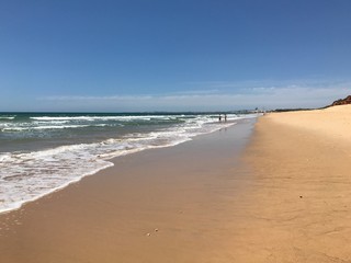 Beautiful beach with only two people walking