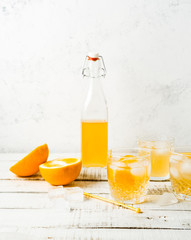 Orange summer drink, fresh oranges on white background. Vertical image