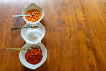 Asia flavoring in the liitle white bowl such as vinegar sugar and chilli fot a kind of noodle Thai style.