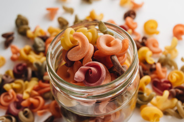 Pile of uncooked bright macaroni on white background