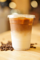 Take away Latte with Coffee bean around on the wood table